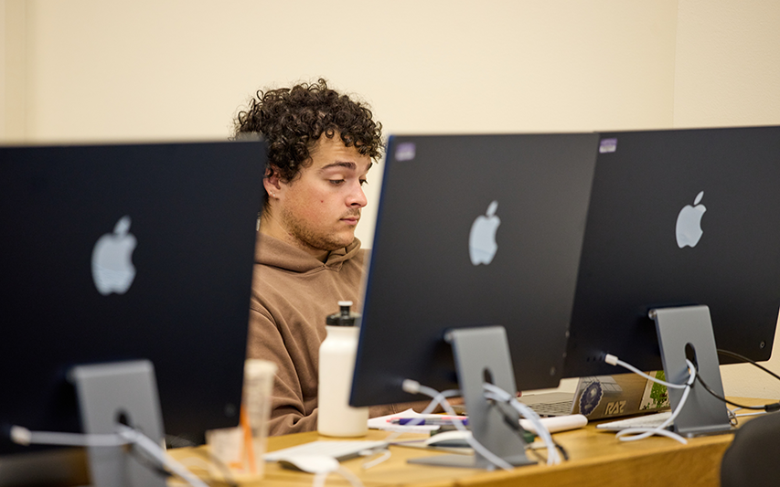 A Curry student works in the MAC Lab in Hafer