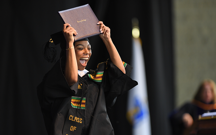 A Curry College graduate screams with delight at receiving her degree