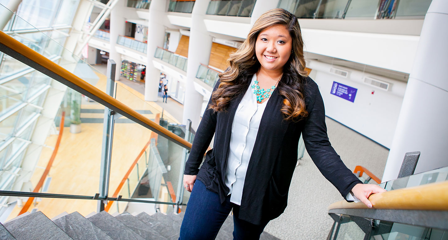 Recent Curry College graduate Christine Nguyen '14 walks up the stairs at her place of employment