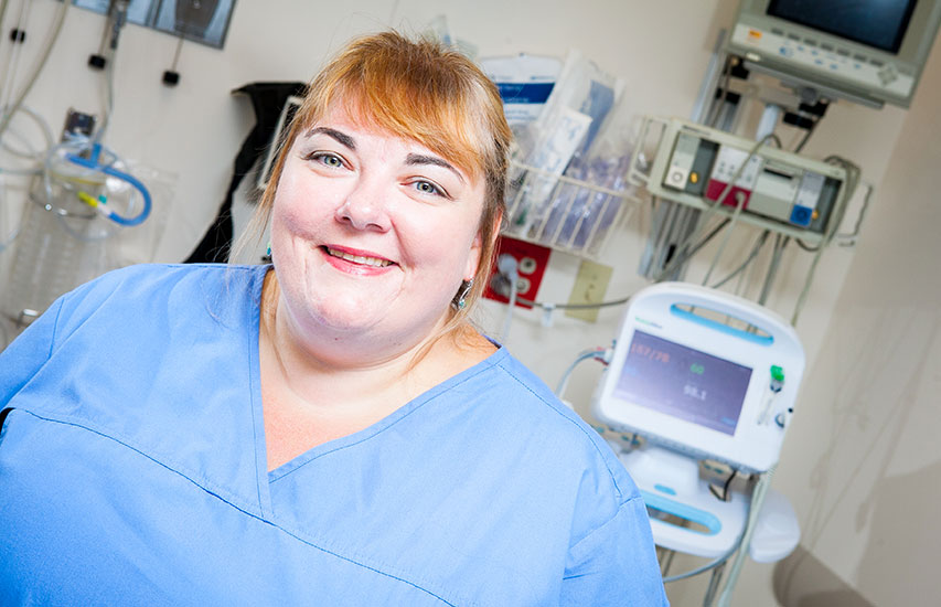 Curry College continuing education alumna in scrubs representing the RN-BS degree program