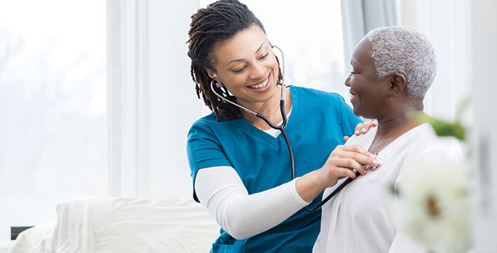 Accelerated Entry MSN at Curry College is represented by a nurse with her patient