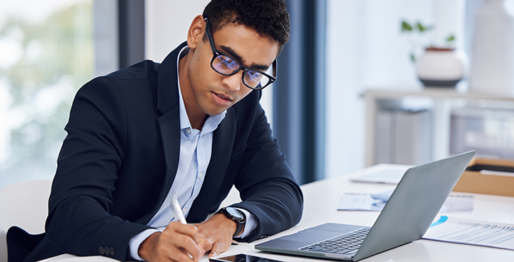 A Curry College Online MBA student works on a laptop