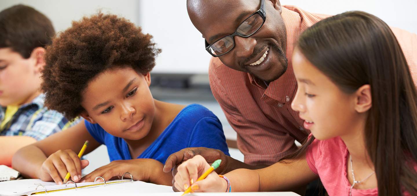 Curry College Education Graduate Programs are represented by a teacher in an elementary school setting