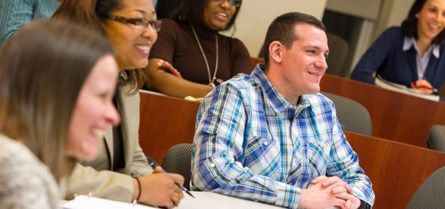 A Curry College Master of Science in Accounting Degree student smiles in class at Curry College