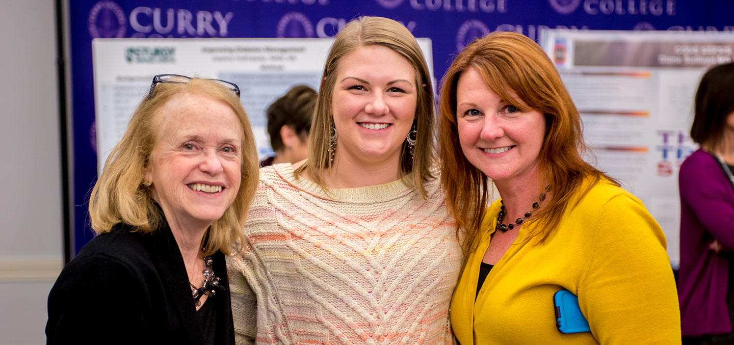 Curry College Master of Science in Nursing (MSN) Degree students and faculty smile after completing a presentation