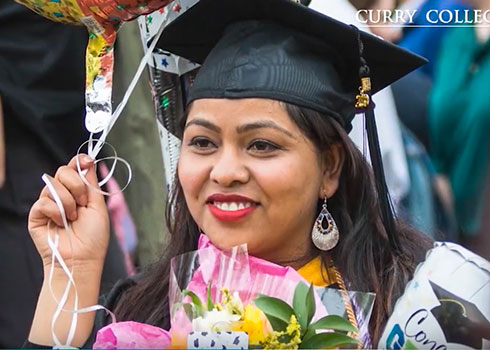 A Curry College student celebrates at her graduation