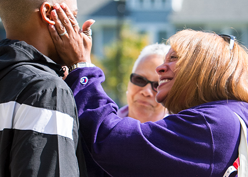 A first-year parent hugs her son