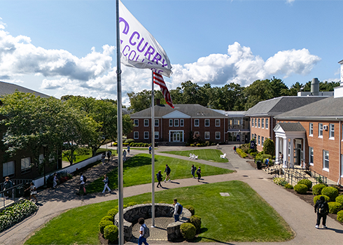 Students walk in Curry College Academic Quad on a sunny day