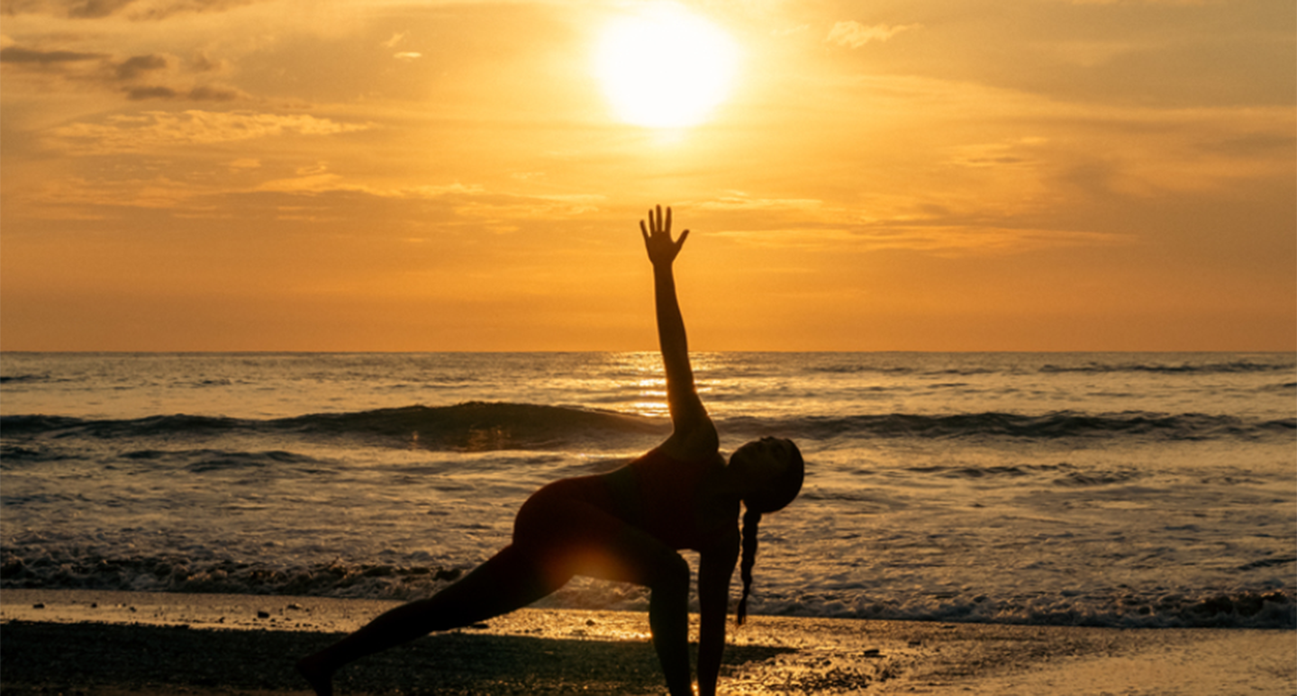 A woman does yoga on the beach in Costa Rica
