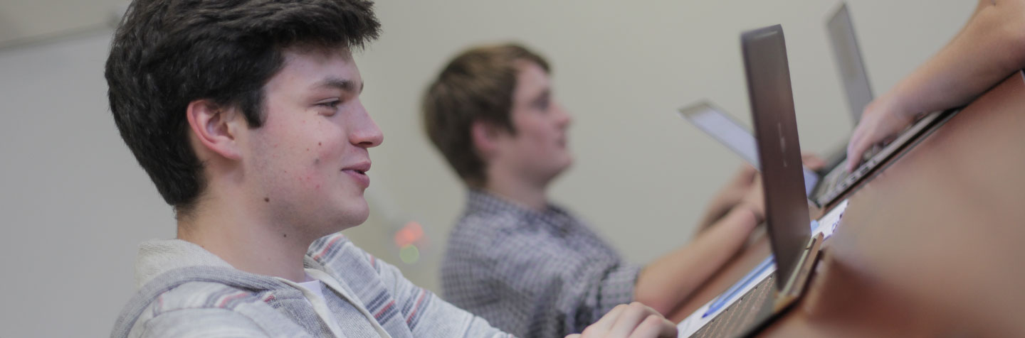 Students using PAL technology in the Curry College Program for Advancement of Learning (PAL) smile for a photo