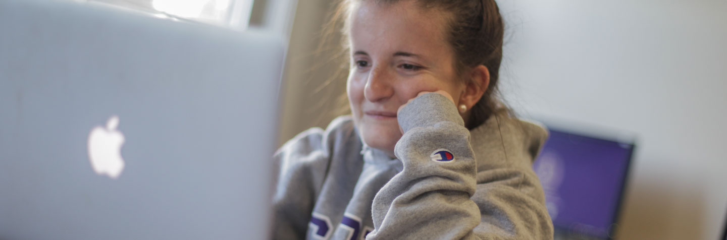 A student on her laptop represents the Curry College Summer PAL Hybrid program