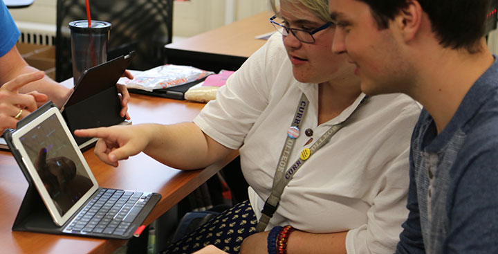 A student and professor work on PAL technology together, using an iPad to assist with the curriculum