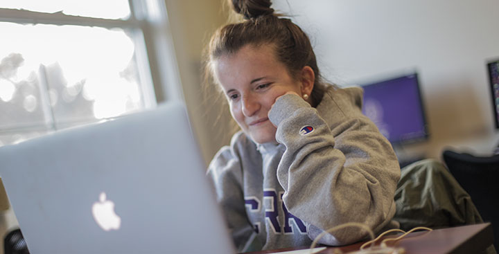 A student on her laptop represents the Curry College Summer PAL Hybrid program