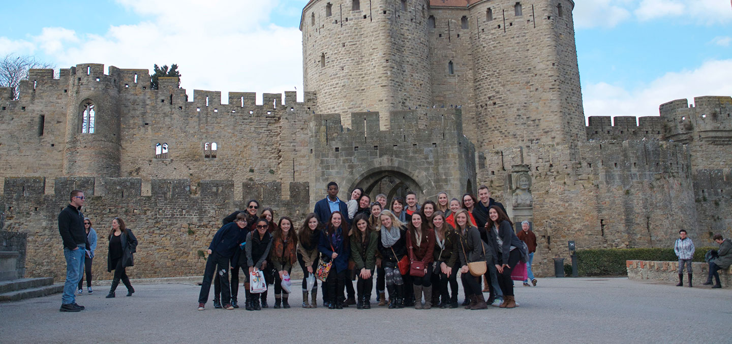Curry College Study Abroad student group poses in fron of a castle in France