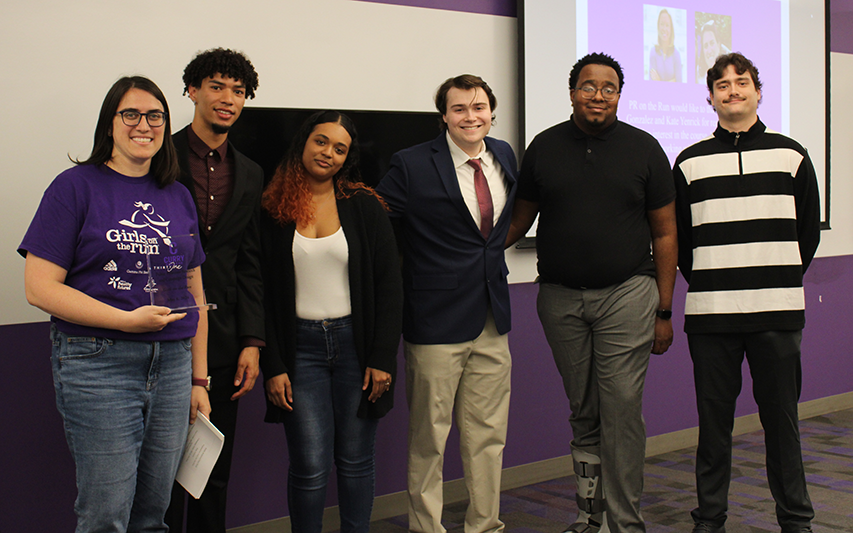 Students pose for a photo after a business presentation