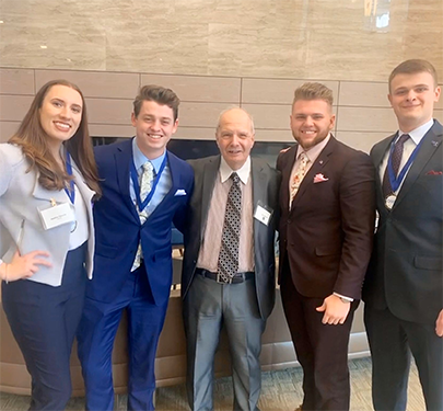 Students in the Curry College DECA chapter pose with their faculty advisor