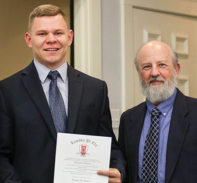 A Curry College faculty member poses with a new member of the COM Honor Society