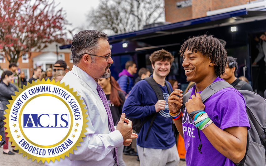 Student pursuing a criminology and criminal justice degree at Curry College converses with his professor