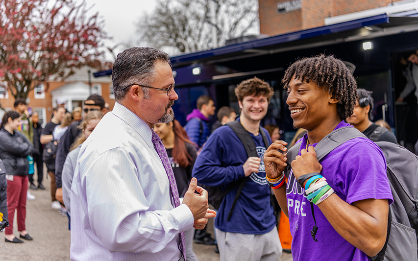 Student pursuing a criminology and criminal justice degree at Curry College converses with his professor