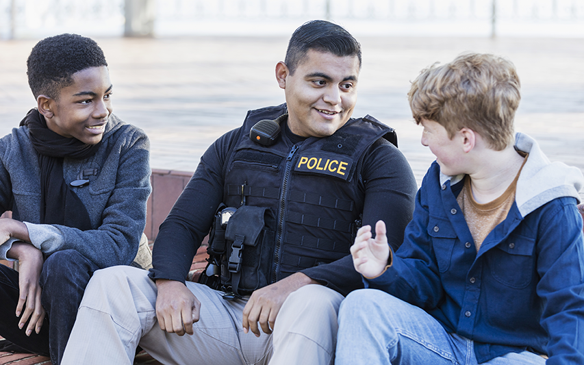 A police officer interacts with two children at the park