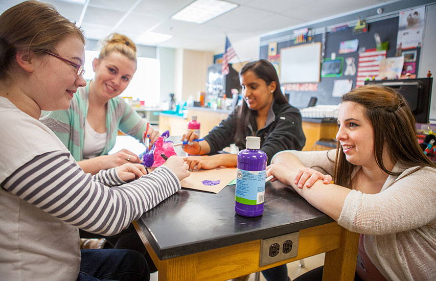 Curry College students work with a child representing the Youth Advocacy minor and concentration