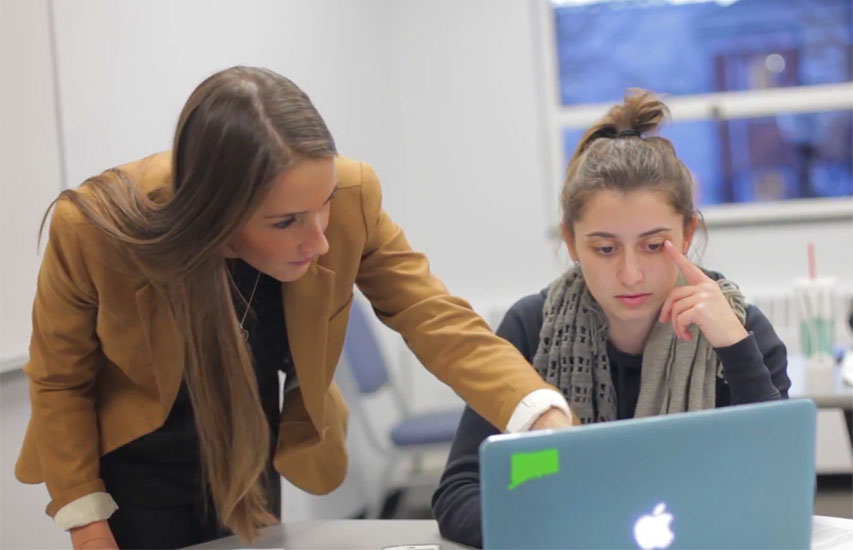 Professor helps a student in class pursuing a Public Health and Wellness degree at Curry College
