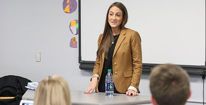 Students and discuss topics in class with professor while pursuing a Public Health and Wellness Degree at Curry College