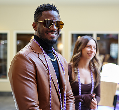 A Curry Nursing Honor Society member poses with his cord