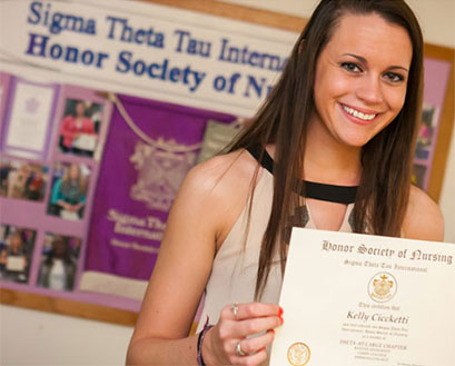 Student member of the Theta at Large Chapter of Sigma Theta Tau holds up her membership certificate