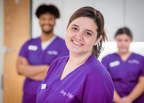 Curry College nursing students in purple scrubs