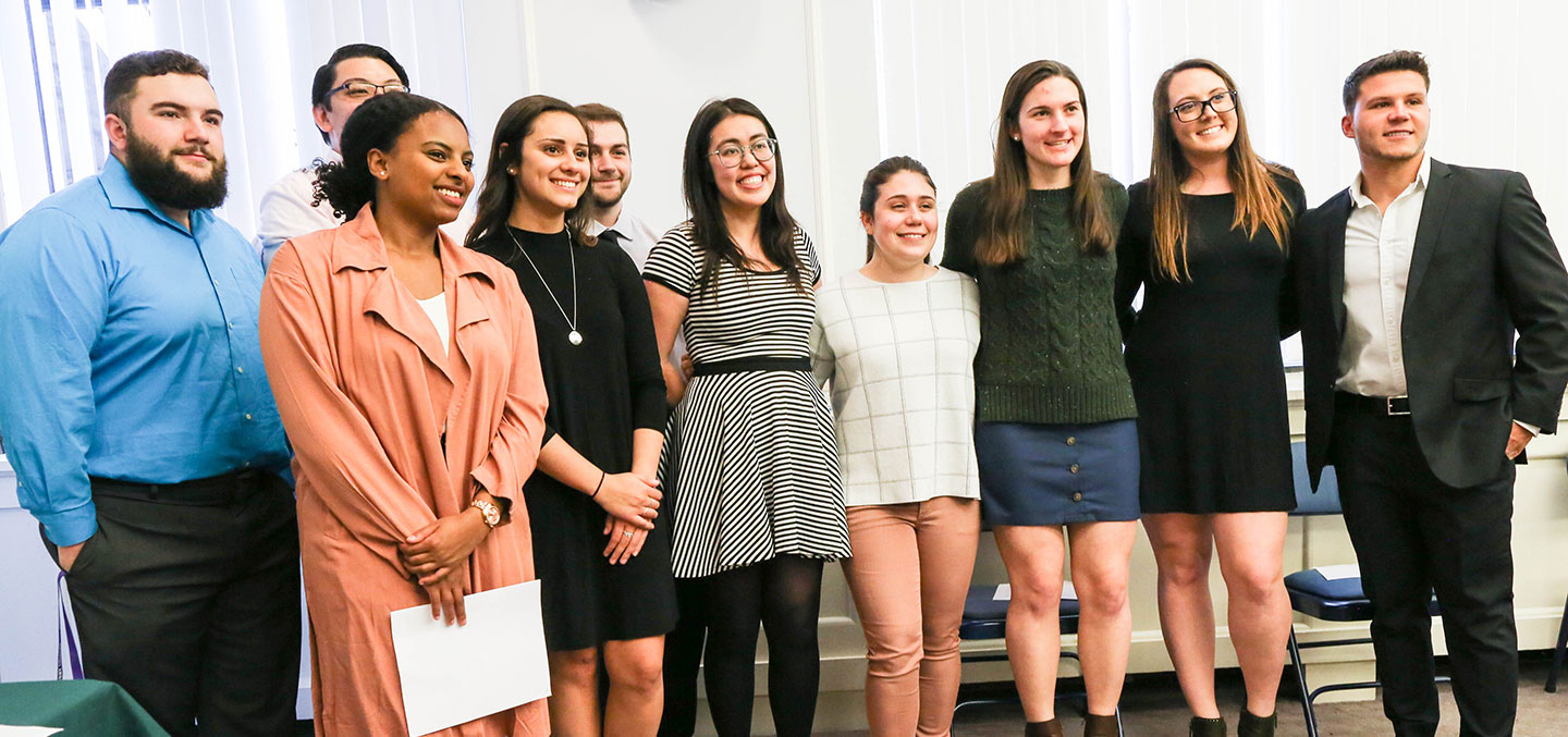 Tri-Beta member poses with friends for photo at induction ceremony