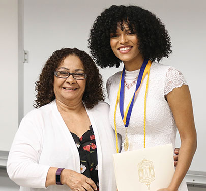 A Curry College student receives her Criminal Justice Honor Society certificate