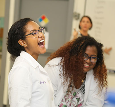 Curry College students laughing in science lab