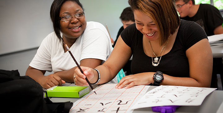 Two students celebrating diversity through their lesson on writing in Mandarin at Curry College