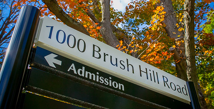A sign leading to the Admission Building on the Curry College campus