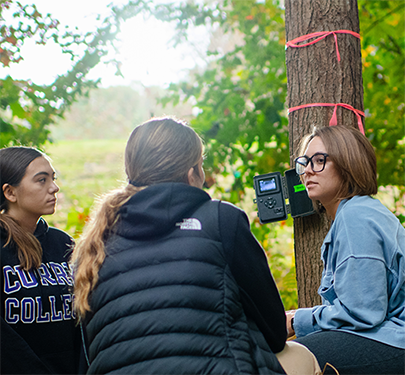 Students and faculty have class in the woods