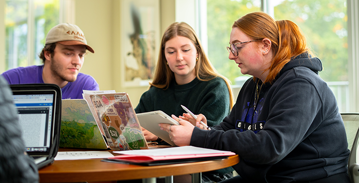 Curry College students on their laptops studying in the Stu Lounge