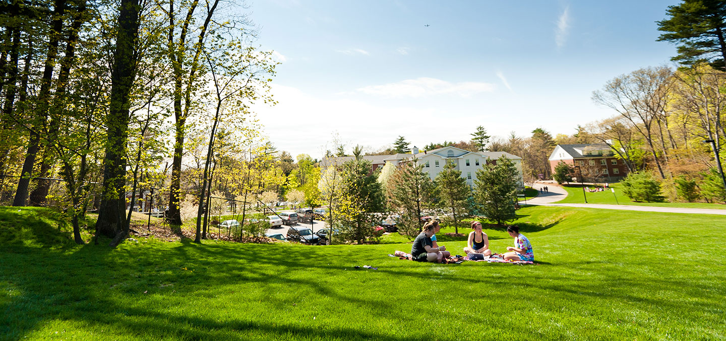 Students walking on the grass representing Admission and Aid at Curry College