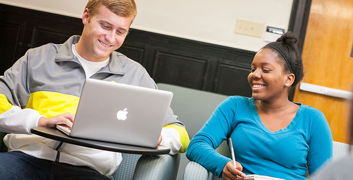 Two students review the Academic Calendars on their laptop