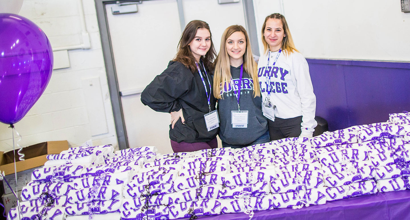 Curry College Accepted Student Day students volunteers hand out T-Shirts