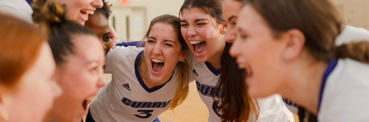 Curry College Women's Volleyball team celebrates a point