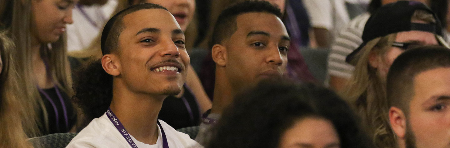 A student in the classroom smiling during a Future Student Reception at Curry College