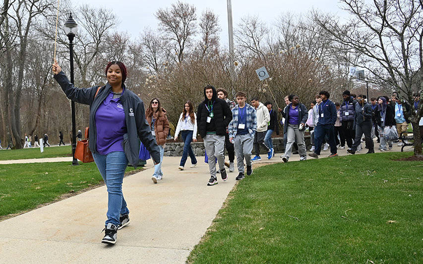 A student tour guide leads a group tour at Curry College