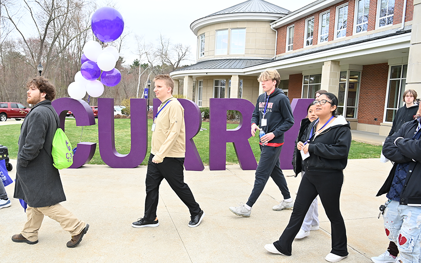 Students walk past the CURRY letters at the Student Center