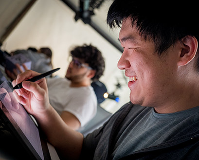 A students works on his tablet in the Curry College ThinkTANK design studio