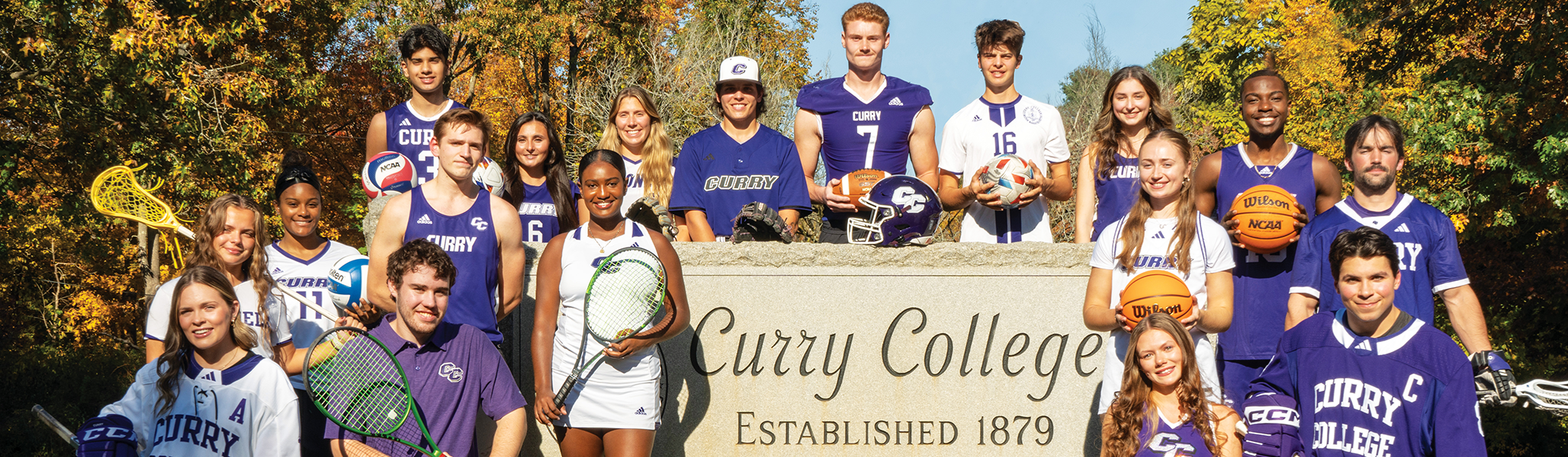 Curry College student-athletes from every sport pose for a photo at the front gate of campus