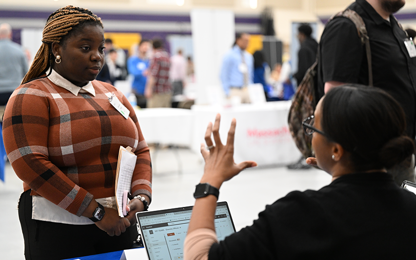 A Curry student interacts with an employer at a career fair
