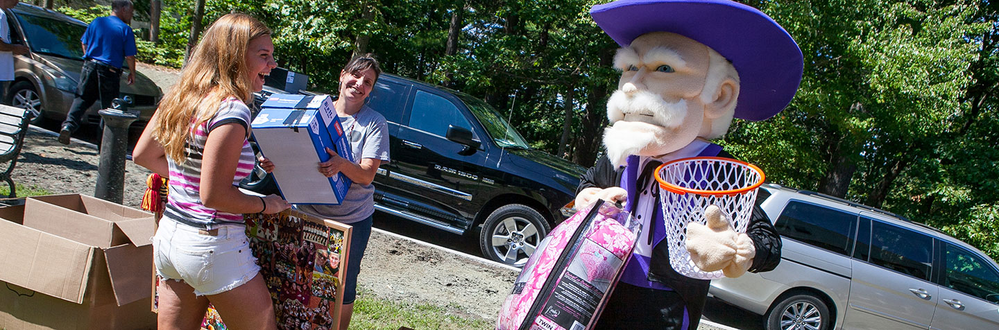 A Curry College student and her mother laugh with the Colonel on Move in Day representing Prospective Parents to the College
