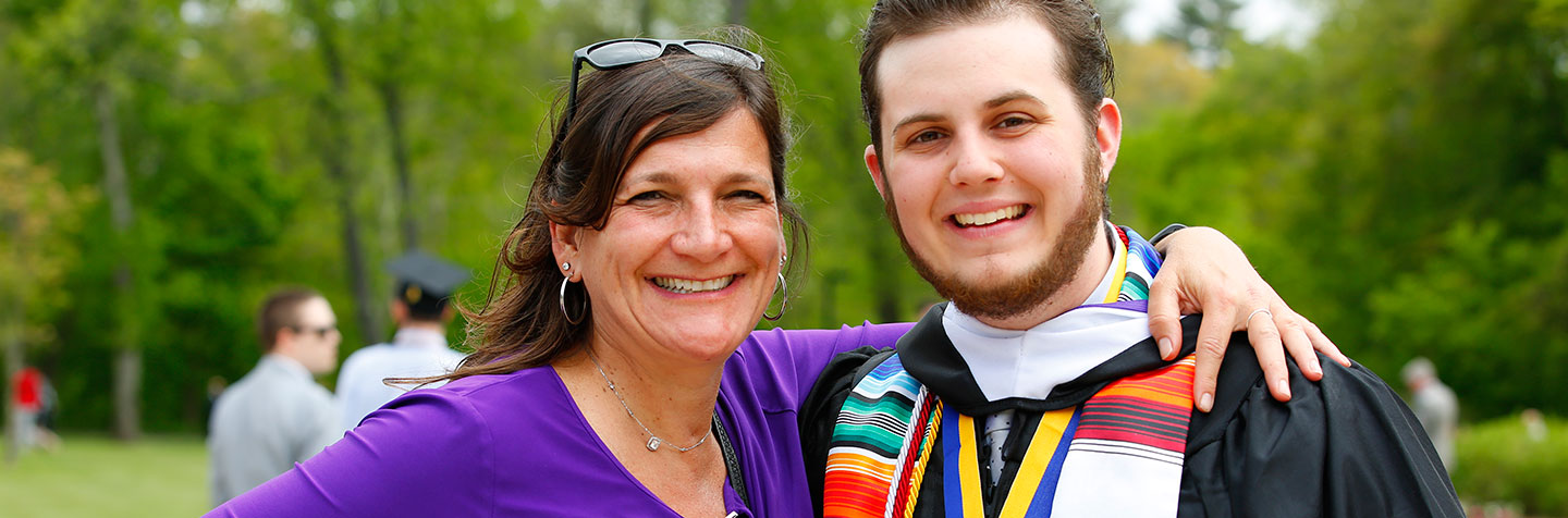 Your Role as a Parent is represented by a Curry College student posing for a pic with his mother at Commencment