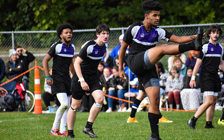 Curry College Men's Rubgy players compete on the field